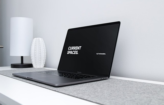 Laptop on a clean desk next to modern decor.