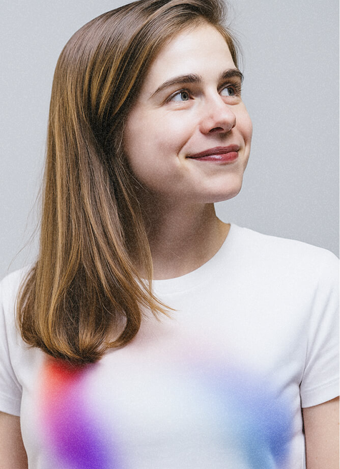 Young woman in a white shirt with a colorful gradient print, against a plain background.